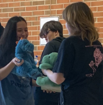  A student from Adairsville (left) and a student from Coahulla Creek (right) bond over their love of dinosaurs and stuffed animals.
